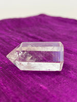 Load image into Gallery viewer, Side View. Beautiful clear crystal point holds both beauty and meaning. Quartz is the &quot;most powerful healing and energy amplifier on the planet&quot; (Judy Hall). It is cleansing to organs of the physical body and It also cleanses the soul and it increases your spiritual energy to the highest level (and so much more). Place this on your altar, book shelf, nightstand or table. Use for meditation, healing, cleansing and more. Point is approximately 1½&quot; tall. Cost is $5.98.
