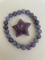 Load image into Gallery viewer, Reverse side of lepidolite star. This lovely little Lepidolite star can be used for meditation, healing, for your altar, on your computer to clear EMRs, or as décor for any room in your home or office. Easy to slip right into your pocket so you can take the energy of lepidolite everywhere you go. Approximately 1¼&quot;. Cost is $6.
