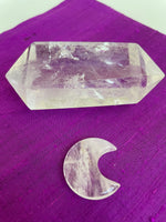 Load image into Gallery viewer, This powerful little quartz crystal crescent moon can be used for meditation, healing, for your altar, or as décor for any room in your home or office. Easy to slip right into your pocket so you can take the energy of quartz everywhere you go.  Quartz is the &quot;most powerful healing and energy amplifier on the planet&quot; (Judy Hall).  Approx. 1¼&quot;. Cost is $6. 
