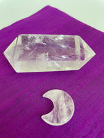 Load image into Gallery viewer, Reverse side of quartz crystal crescent moon. This powerful little quartz crystal crescent moon can be used for meditation, healing, for your altar, or as décor for any room in your home or office. Easy to slip right into your pocket so you can take the energy of quartz everywhere you go. Quartz is the &quot;most powerful healing and energy amplifier on the planet&quot; (Judy Hall). Approx. 1¼&quot;. Cost is $6.
