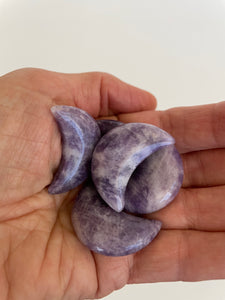 View of several lepidolite crescent moons. This sparkly little lepidolite crescent moon can be used for meditation, healing, for your altar, on/near your computer or as décor for any room in your home or office. Easy to slip right into your pocket so you can take the energy of lepidolite everywhere you go. Approx. 1¼". Cost is $6 for one moon.