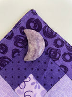 Load image into Gallery viewer, Reverse side of lepidolite crescent moon. This sparkly little lepidolite crescent moon can be used for meditation, healing, for your altar, on/near your computer or as décor for any room in your home or office. Easy to slip right into your pocket so you can take the energy of lepidolite everywhere you go. Approx. 1¼&quot;. Cost is $6.
