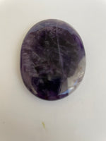 Load image into Gallery viewer, Back side of Chevron amethyst palm stone. Beautiful amethyst palm stone can be used for meditation, healing, for your altar or as a décor item. Amethyst, one of the most spiritual gemstones, heals, cleanses &amp; calms, allowing you to reach meditative &amp; higher consciousness levels more easily. It also helps to dispel negative emotional states and more. Chevron amethyst is a combination of amethyst and white quartz and when you add the quartz you get additional qualities. 2&quot; long. Cost $12.
