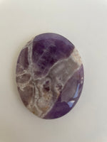 Load image into Gallery viewer, Close up - front. Lovely lavender colored Chevron amethyst palm stone can be used for meditation, healing, for your altar or as a décor item. Amethyst, one of the most spiritual gemstones, heals, cleanses &amp; calms, allowing you to reach meditative &amp; higher consciousness levels more easily. It also helps to dispel negative emotional states and more. Chevron amethyst is a combination of amethyst and white quartz and when you add the quartz you get additional qualities. 2&quot; long. Cost is $12.
