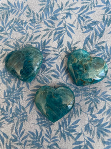 View of several hearts. Love this blue apatite heart! Great to carry in your pocket, place on your altar or bookshelf or to hold during meditation. Apatite enhances manifestation, aids psychic abilities and meditation, helps you to express yourself verbally, aids in reaching high levels of spiritual guidance, boosts creativity and helps to ease anger and irritation (along with other wonderful qualities). The apatite heart is approximately 1¼" at it's widest/longest expanse. Cost is $6