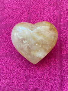 Alternate view/front. Beautiful citrine (yellow quartz) heart! Great to place on your altar or bookshelf, to hold during meditation, to use for healing or as a décor item in your home of office. Citrine absorbs and dispels negative energy, is a stone of abundance - attracting money, prosperity and success, warming & energizing, enhances creativity, brings a positive attitude, is cleansing and more. This citrine heart is approximately 2" at it's widest expanse. Cost is $24.