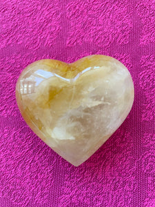 Alternate view/front. Beautiful citrine (yellow quartz) heart! Great to place on your altar or bookshelf, to hold during meditation, to use for healing or as a décor item in your home of office. Citrine absorbs and dispels negative energy, is a stone of abundance - attracting money, prosperity and success, warming & energizing, enhances creativity, brings a positive attitude, is cleansing and more. This citrine heart is approximately 2" at it's widest expanse. Cost is $24.