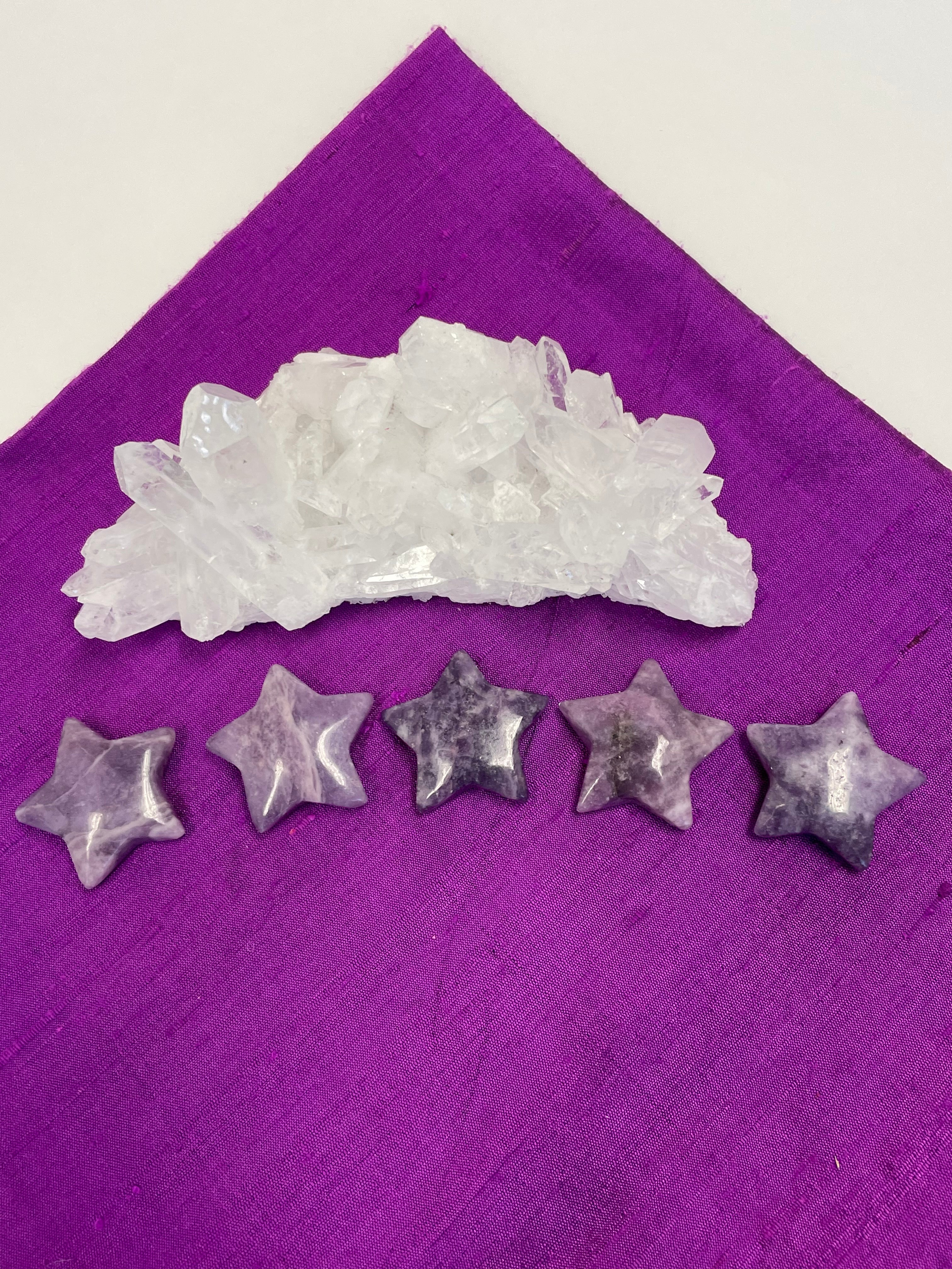 View of several lepidolite stars. This lovely little Lepidolite star can be used for meditation, healing, for your altar, on your computer to clear EMRs, or as décor for any room in your home or office. Easy to slip right into your pocket so you have the energy of lepidolite everywhere you go. Approximately 1¼". Cost is $6 for one star. 