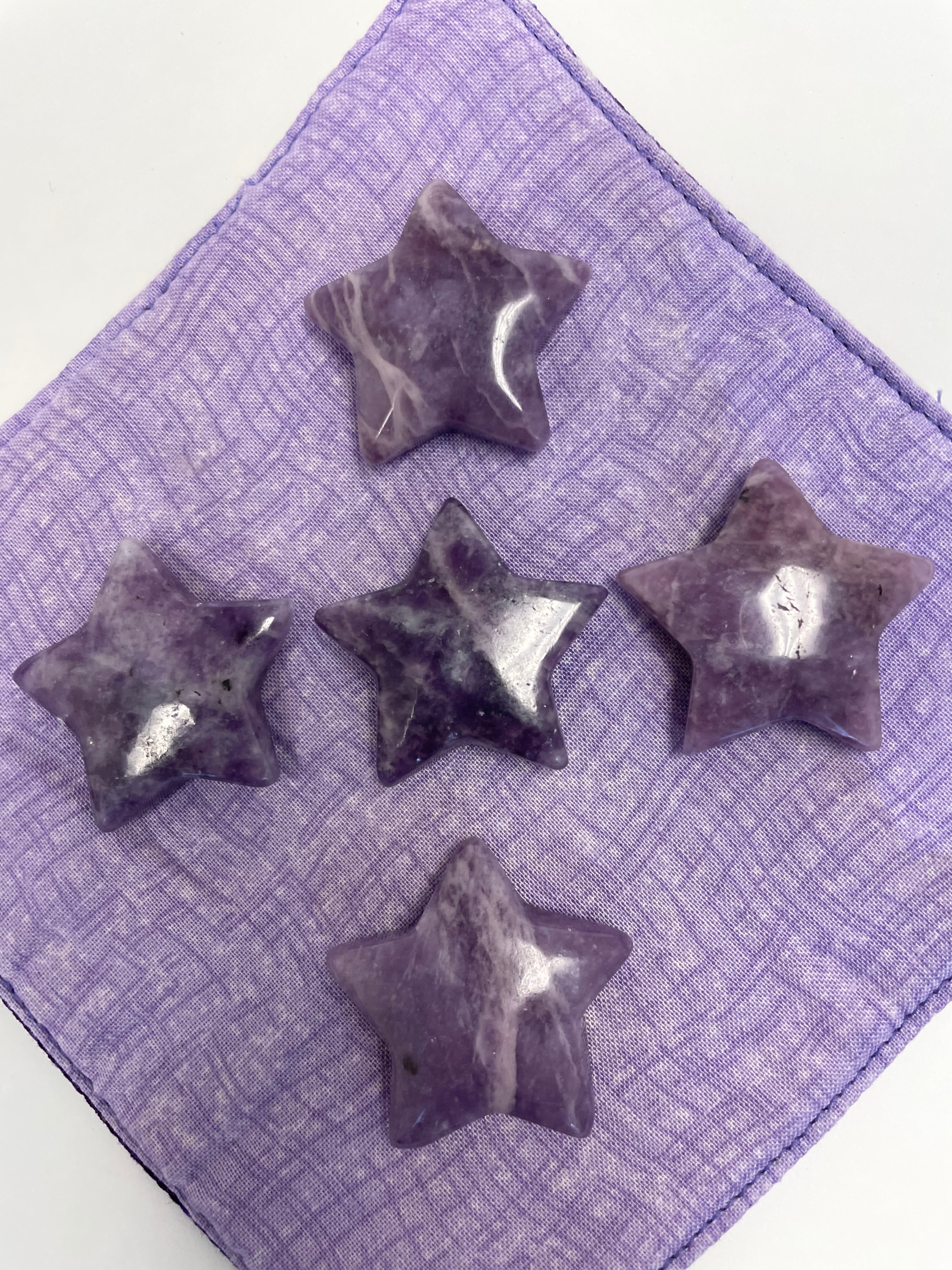 Another view of several lepidolite stars. This lovely little Lepidolite star can be used for meditation, healing, for your altar, on your computer to clear EMRs, or as décor for any room in your home or office. Easy to slip right into your pocket so you can take the energy of lepidolite everywhere you go. Approximately 1¼". Cost is $6 for one star. 