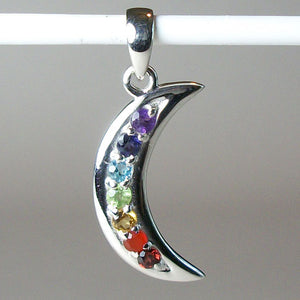 Another close-up view of the Chakra crescent moon pendant. Small faceted stones represent each of the chakras: amethyst/crown, iolite/third eye, blue topaz/throat, peridot/heart, citrine/solar plexus, carnelian/sacral (or naval), garnet/root (or base). These small, faceted stones are set, in a curve, along a solid sterling crescent moon. Pendant is approximately 1¼".