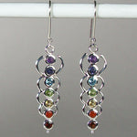 Load image into Gallery viewer, Close-up view. Chakra energy link earrings. Small faceted stones that represent each of the chakras: amethyst/crown, iolite/third eye, blue topaz/throat, peridot/heart, citrine/solar plexus, carnelian/sacral (or naval), garnet/root (or base). These stones are set in links or loops of sterling silver, two per loop or link go straight down the middle. Wires not posts and approximately 1¾&quot;.
