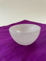 Load image into Gallery viewer, If you look closely, you can see the sparkles in this beautiful carved selenite bowl. It can be used for cleansing and charging your crystals and jewelry because it dispels negative and unwanted energies. Selenite also promotes clarity of mind, opens the crown chakra, helps to access angelic energies and guidance from the higher realms. It brings peace and is a great stone to use while meditating or connecting spiritually and more. The bowls are approximately 2¾&quot;-3&quot; in diameter. Cost is $12.
